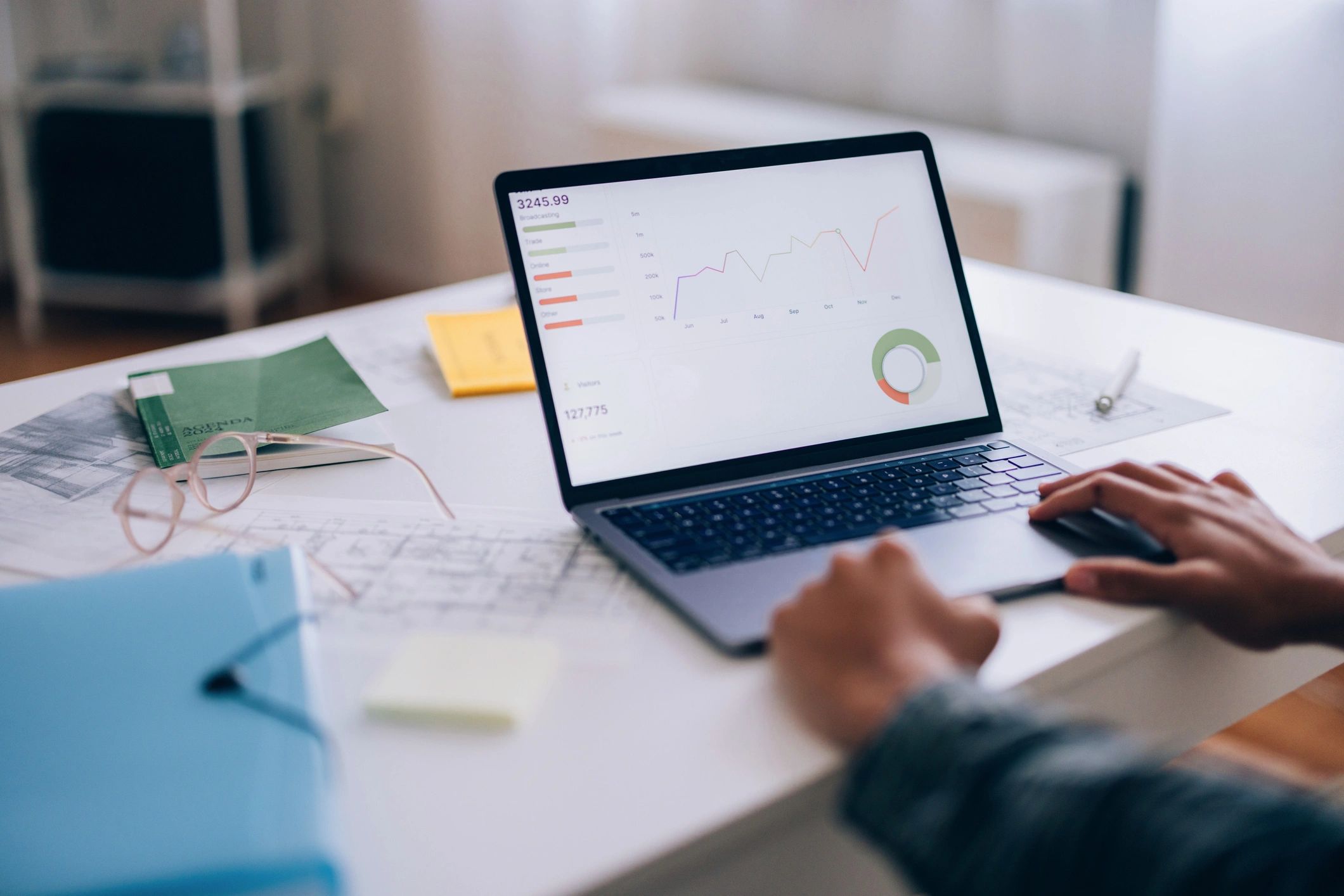 Person analyzing real estate market graphs on a laptop