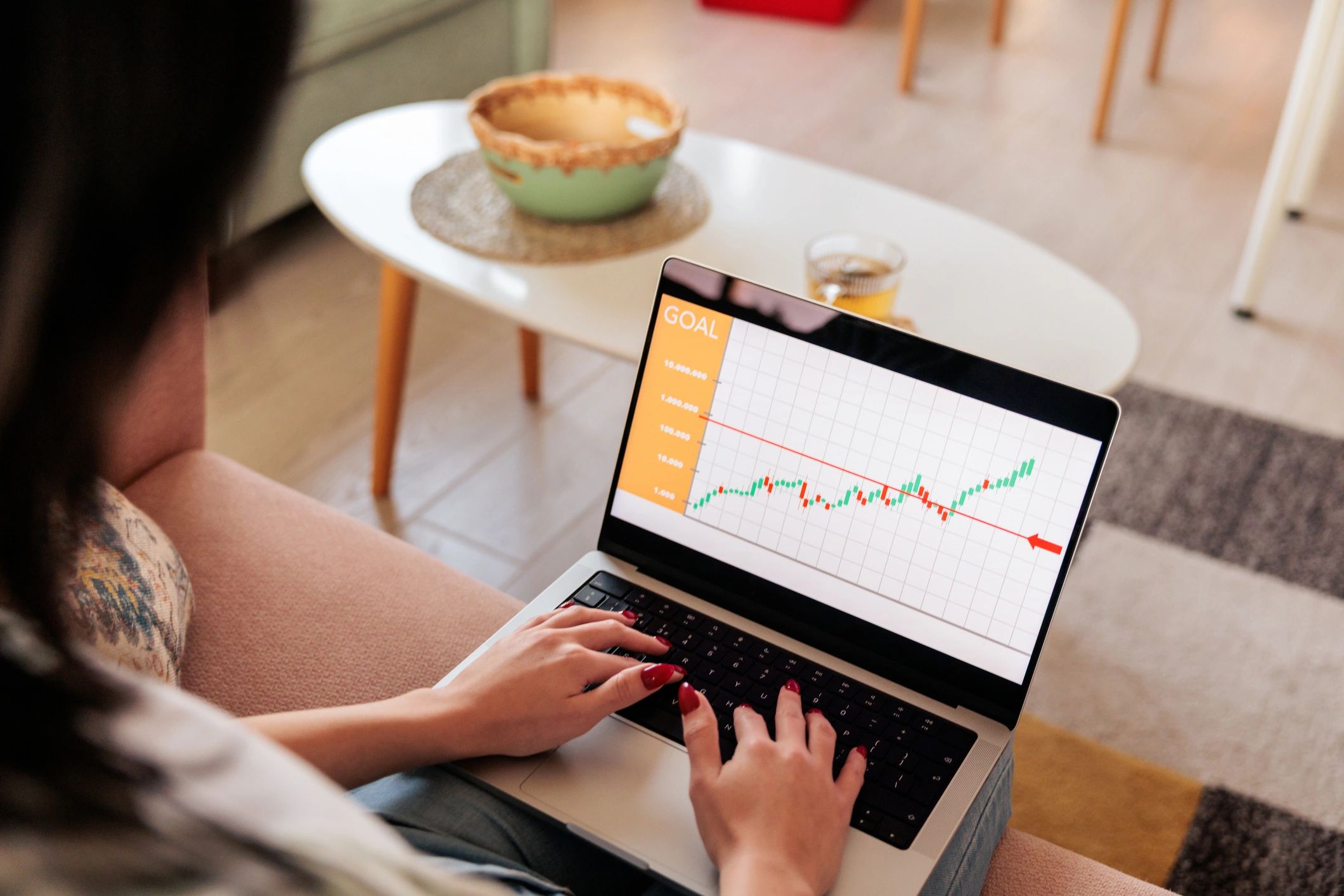 Woman reviewing investment growth chart on a laptop